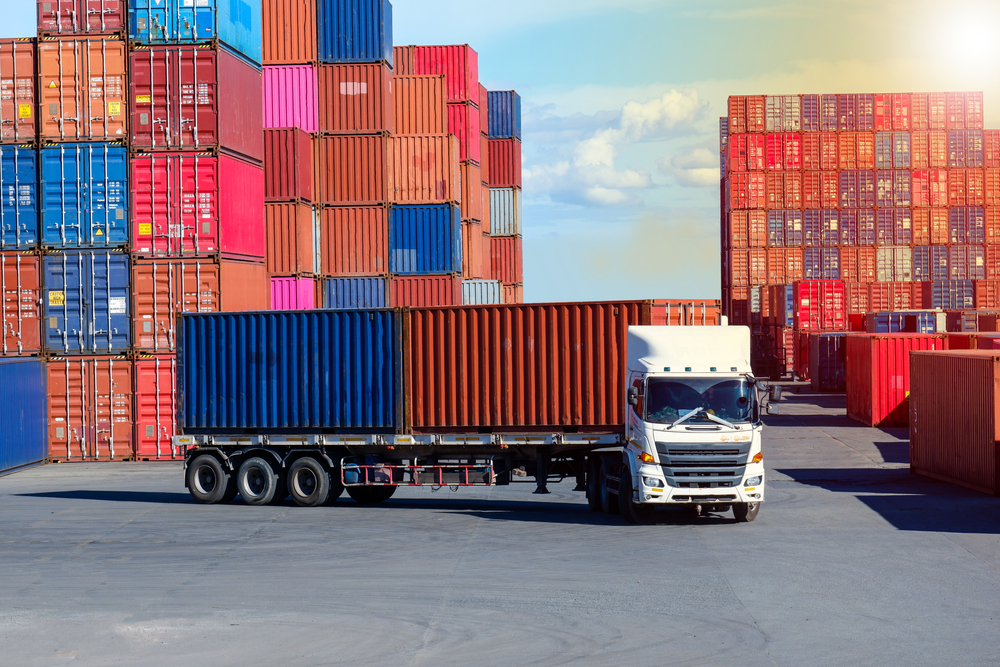 fine art logistics a truck in a storage yard filled with shipping containers