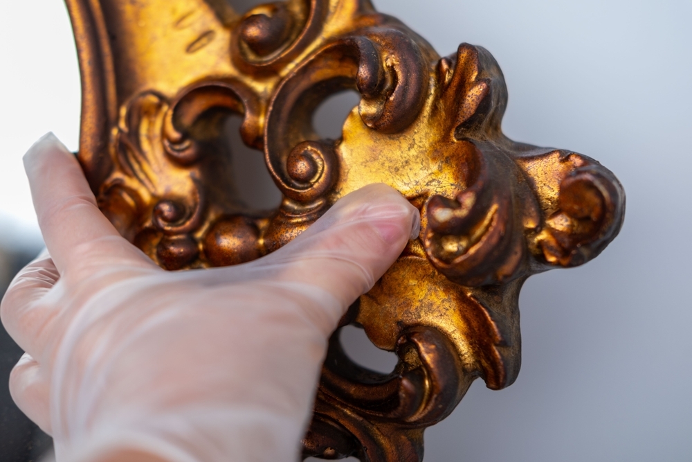 hand holding gold statue