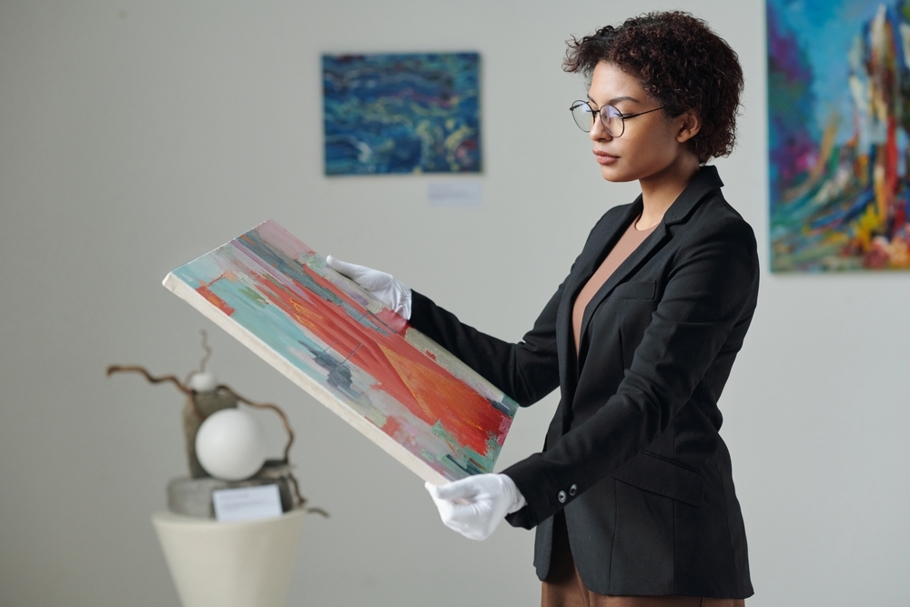 museum curator carefully inspecting a painting after white glove fine art shipping