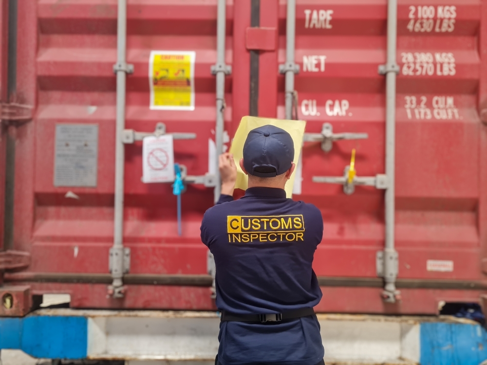 customs officer inspecting shipping crates